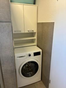 a washer and dryer in a small room at Gemütliches Ferienhaus mit Sauna an der Nordsee in Sehestedt