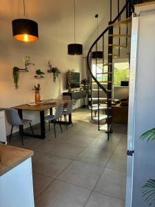 a kitchen and dining room with a table and a spiral staircase at Gemütliches Ferienhaus mit Sauna an der Nordsee in Sehestedt +17 photos