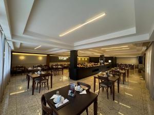 a restaurant with tables and chairs and a buffet at Luz Hotel Pato Branco in Pato Branco