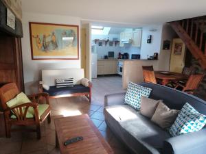 a living room with a couch and a kitchen at Gîte Kersonan in Saint-Jean-Brévelay