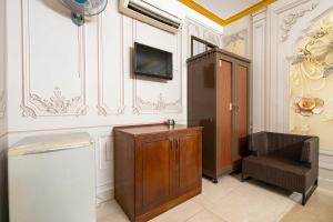 a living room with a tv and a cabinet and a televisionicter at Collection O Bao Duy Hotel in Ho Chi Minh City