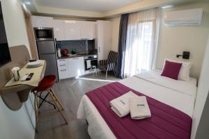 a bedroom with a large bed and a kitchen at Pyrgiou suites in Thessaloniki