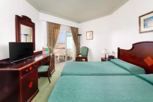a hotel room with a bed and a desk with a television at Hotel Riu Oliva Beach Resort - All Inclusive in Corralejo +19 photos