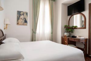 a bedroom with a white bed and a window at Hotel Boccaccio in Florence