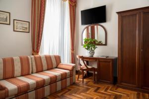 a living room with a couch and a desk at Hotel Boccaccio in Florence