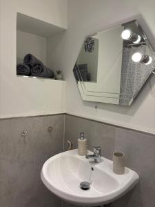 a bathroom with a white sink and a mirror at Klytti‘s Pension in Sendenhorst +3 photos