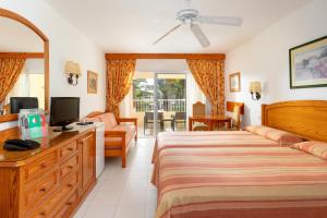a bedroom with a bed and a tv and a couch at Hotel Riu Oliva Beach Resort - All Inclusive in Corralejo