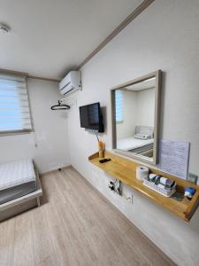 a room with a mirror and a bed and a television at 24 Guesthouse Suncheon in Suncheon