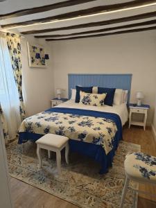 a blue and white bedroom with a bed and a chair at Arturana turismo in Ollauri