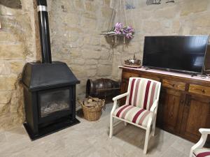 a living room with a wood stove and a chair at Arturana turismo in Ollauri