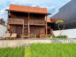 a wooden house with a deck and two chairs at Kalyana Gangga in Krambitan +13 photos
