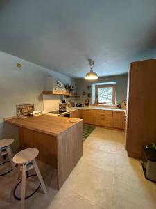 eine große Küche mit einer hölzernen Arbeitsplatte und Hockern in der Unterkunft Chalet Angelo in Ponte di Legno + 19 Fotos