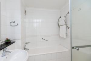 a white bathroom with a sink and a shower at 5-Min Walk to CTICC - Central & Cosy Hotel Stay in Cape Town +21 photos