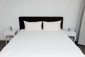 a large white bed with two nightstands and two lamps at 5-Min Walk to CTICC - Central & Cosy Hotel Stay in Cape Town