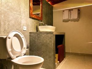 a bathroom with a toilet and a sink at Kalyana Gangga in Krambitan