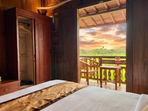 a bedroom with a window looking out onto a balcony at Kalyana Gangga in Krambitan