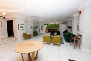a living room with tables and chairs and a couch at 5-Min Walk to CTICC - Central & Cosy Hotel Stay in Cape Town