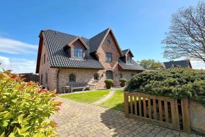 a house with a wooden gate in front of it at Ferienhaus Fiete in Tinnum