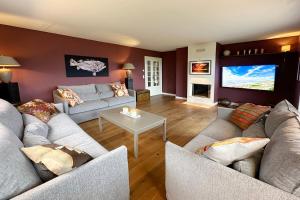 a living room with two couches and a flat screen tv at Ferienhaus Fiete in Tinnum