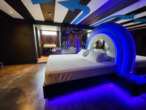 a bedroom with a bed with a blue lighting at Andar de Cima Suítes in São Paulo