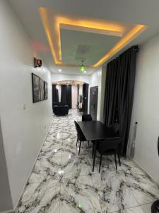 a living room with a table and chairs on a marble floor at Apartment 67 in Akinyele
