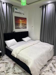 a bedroom with a large bed with white sheets at Apartment 67 in Akinyele