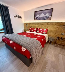 a bedroom with a bed with a red blanket at B&B Ciesa la Vèrda in Rocca Pietore