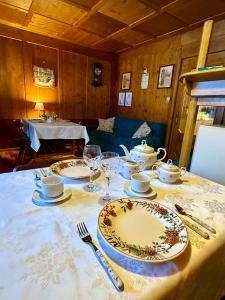 a table with plates and wine glasses on it at B&B Ciesa la Vèrda in Rocca Pietore +4 photos
