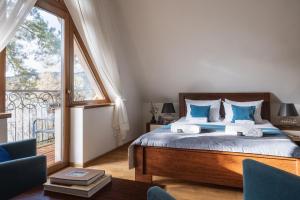a bedroom with a bed and a large window at Wilcznik 10 in Zakopane