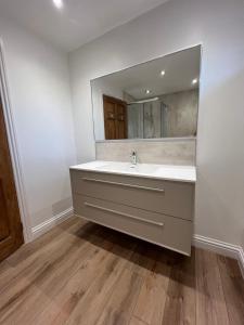 a bathroom with a sink and a mirror at Dwarwick House in Thurso