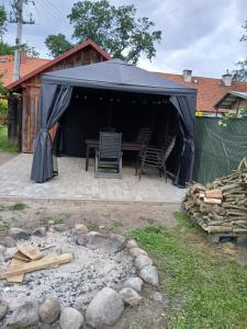 a black tent with chairs and a table in a yard at Dom Odpoczynku Mazury in Sorkwity