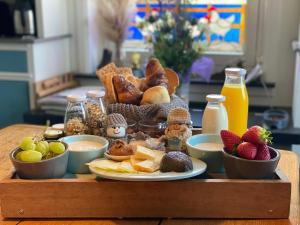 a tray of food with bread and fruit on a table at De Bommelerhoeve B&B & Vakantiewoning Dirkje in Poederoijen
