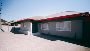 a small house with a red roof and a driveway at Lodge36 in Vanderbijlpark