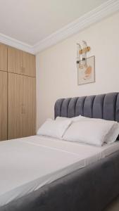 a bedroom with a large bed with a gray headboard at Résidence-MDKM in Abidjan