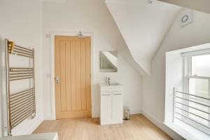 a bathroom with a sink and a wooden door at Apt 3 Armatage Flats, Eyemouth in Eyemouth +14 photos