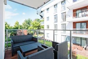 a balcony with a table and chairs on a building at Flatbook - Seaside Apartments Tre Mare II in Gdańsk