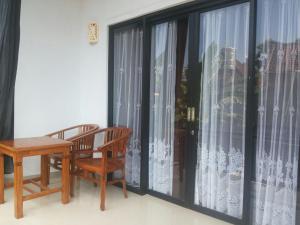 a room with a table and chairs and a large window at D Jana in Amed