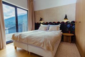 a bedroom with a large bed with a large window at Ґонт - затишний будинок з чаном біля Буковелю in Tatariv