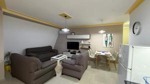 a living room with two couches and a table and a tv at Your Home in Pogradec