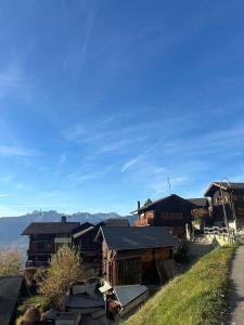 a group of buildings with mountains in the background at Mayen unique et authentique in Vernamiège