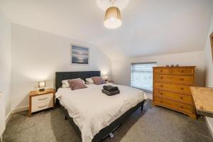 a bedroom with a bed and a wooden dresser at Spacious Three Bedroom Flat in Filey Town Centre with Workspace in Filey