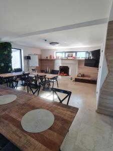 a living room with tables and chairs and a fireplace at Solaris Zenith View in Buşteni