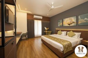 a hotel room with a bed and a television at Nilayat Inn in Ollūr