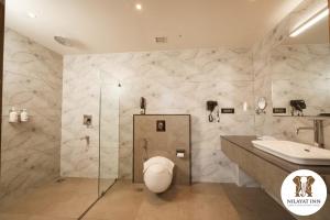 a bathroom with a toilet and a sink at Nilayat Inn in Ollūr
