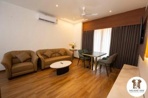 a living room with a couch and a table at Nilayat Inn in Ollūr