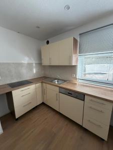 a kitchen with white cabinets and a sink and a window at Ferienhaus Fünf Täler in Geislingen an der Steige