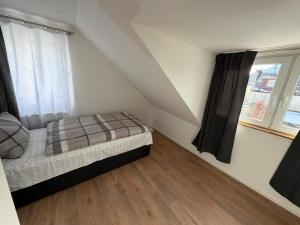 a small bedroom with a bed and two windows at Ferienhaus Fünf Täler in Geislingen an der Steige