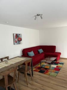 a living room with a red couch and a table at Ferienwohnung Alkapa in Hilzingen