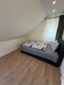 a bed sitting in a room with a window at Ferienhaus Fünf Täler in Geislingen an der Steige