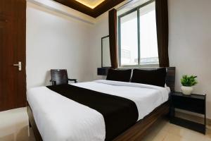 a bedroom with a large bed and a window at HOTEL O MJ INN in Darbhanga